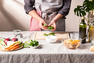Una persona en un delantal preparando comida en una mesa