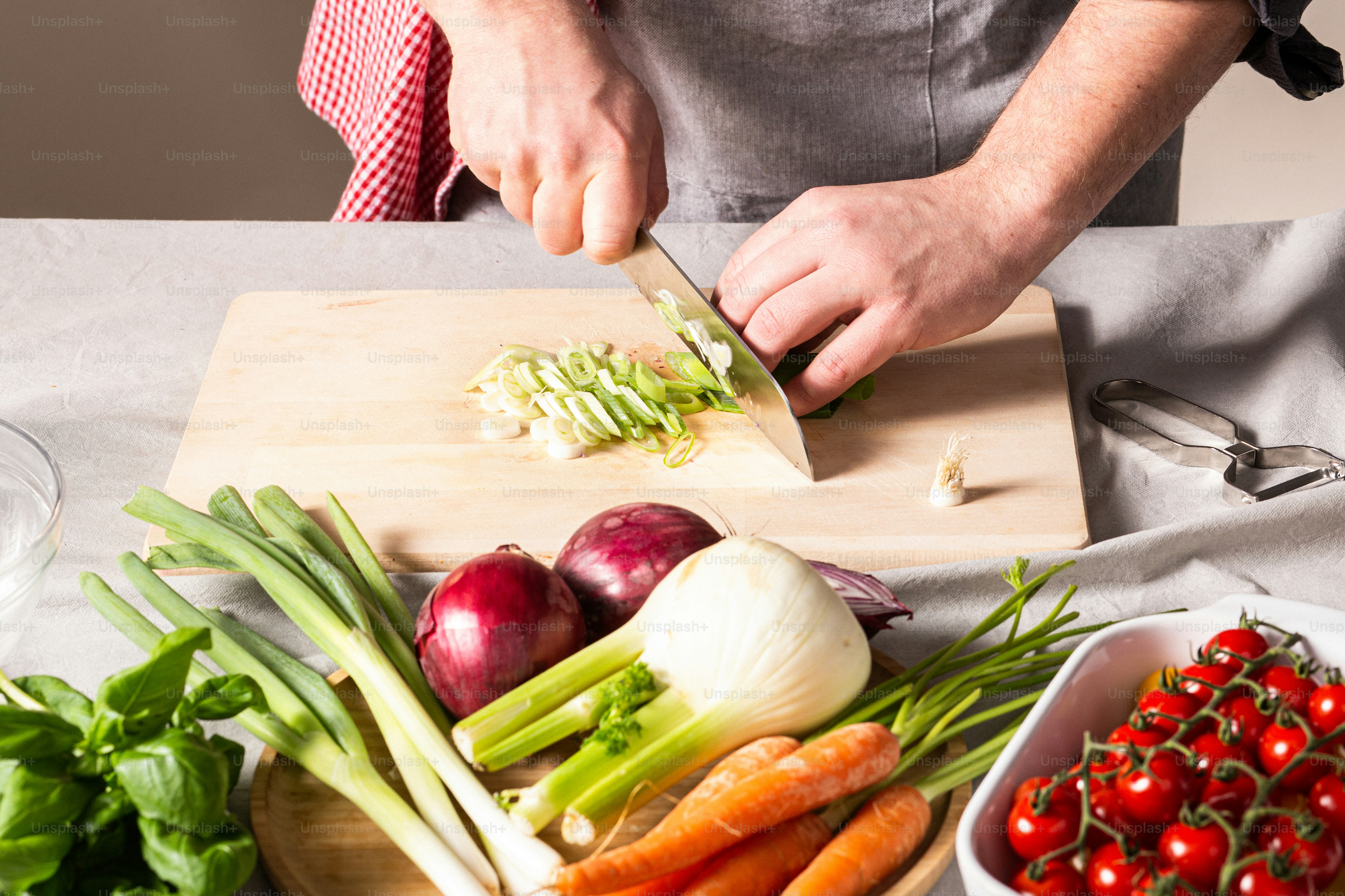 a person cutting up vegetables on a cutting board