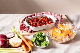 uma mesa coberta com uma tigela de frutas e legumes