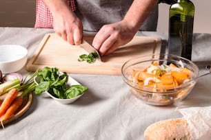 a person cutting up vegetables on a cutting board