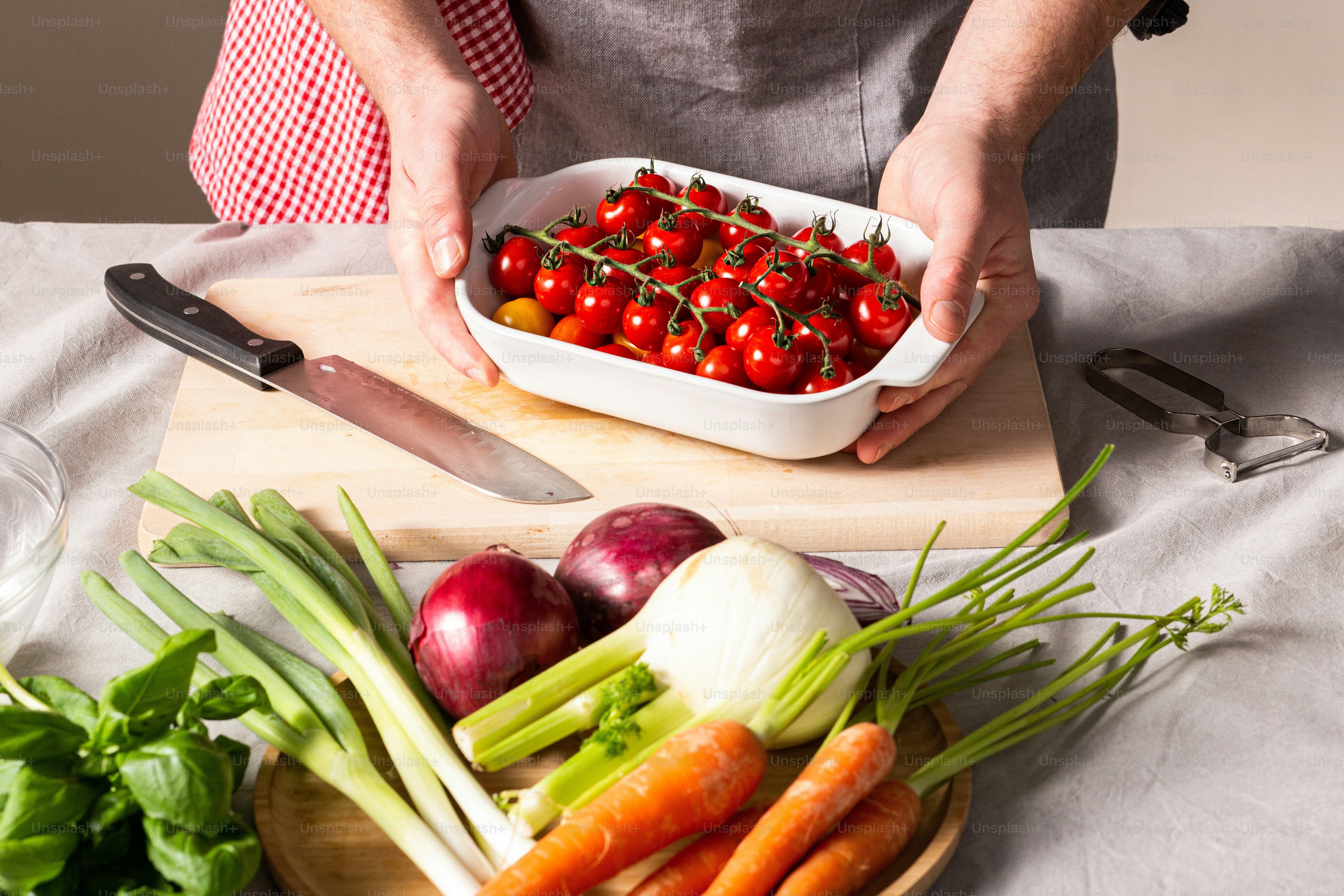 a person holding a bowl of vegetables on a table