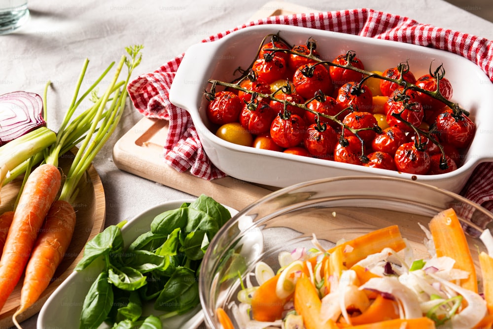 Un plato de tomates, zanahorias y apio en una mesa