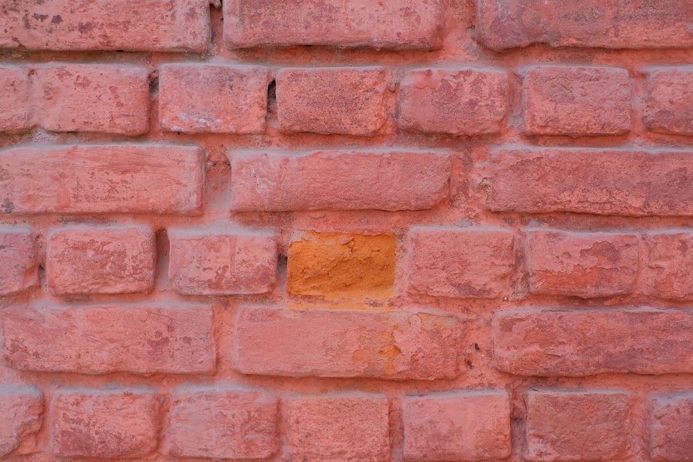 a close up of a brick wall with a yellow square on it