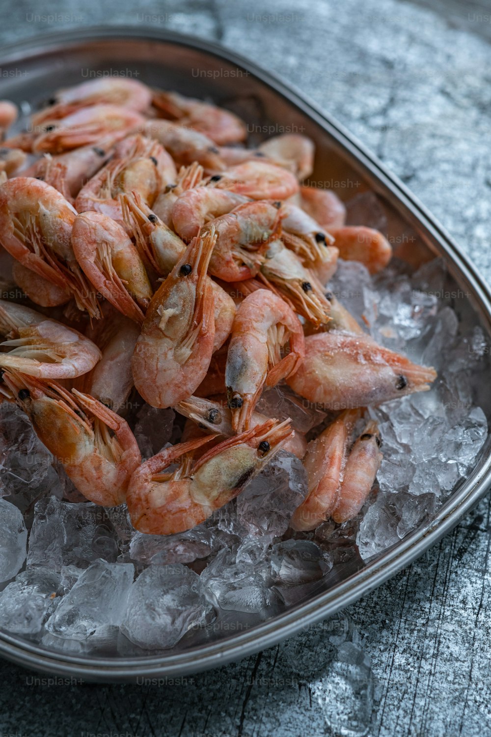 une assiette de crevettes sur de la glace sur une table