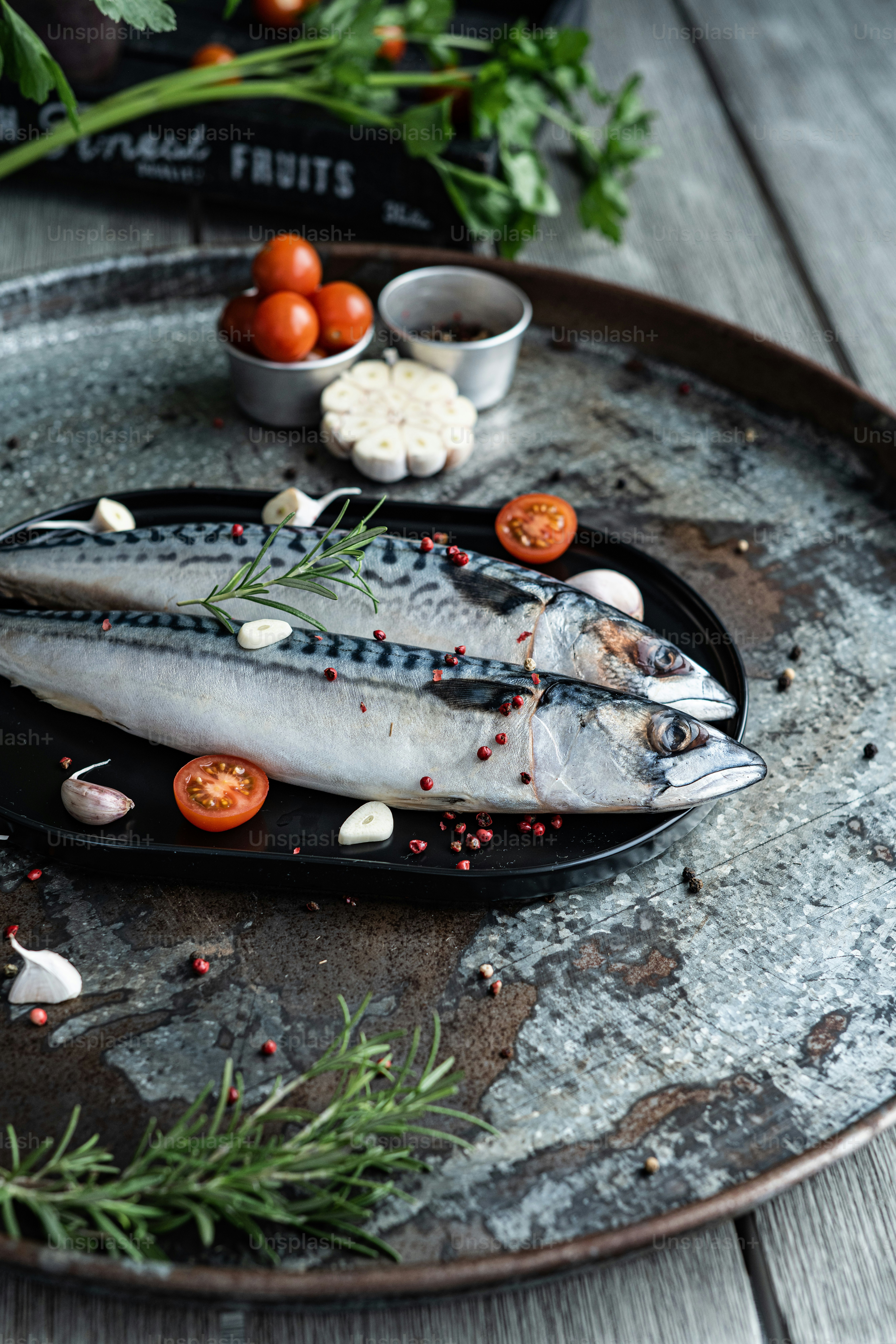 a couple of fish sitting on top of a black plate