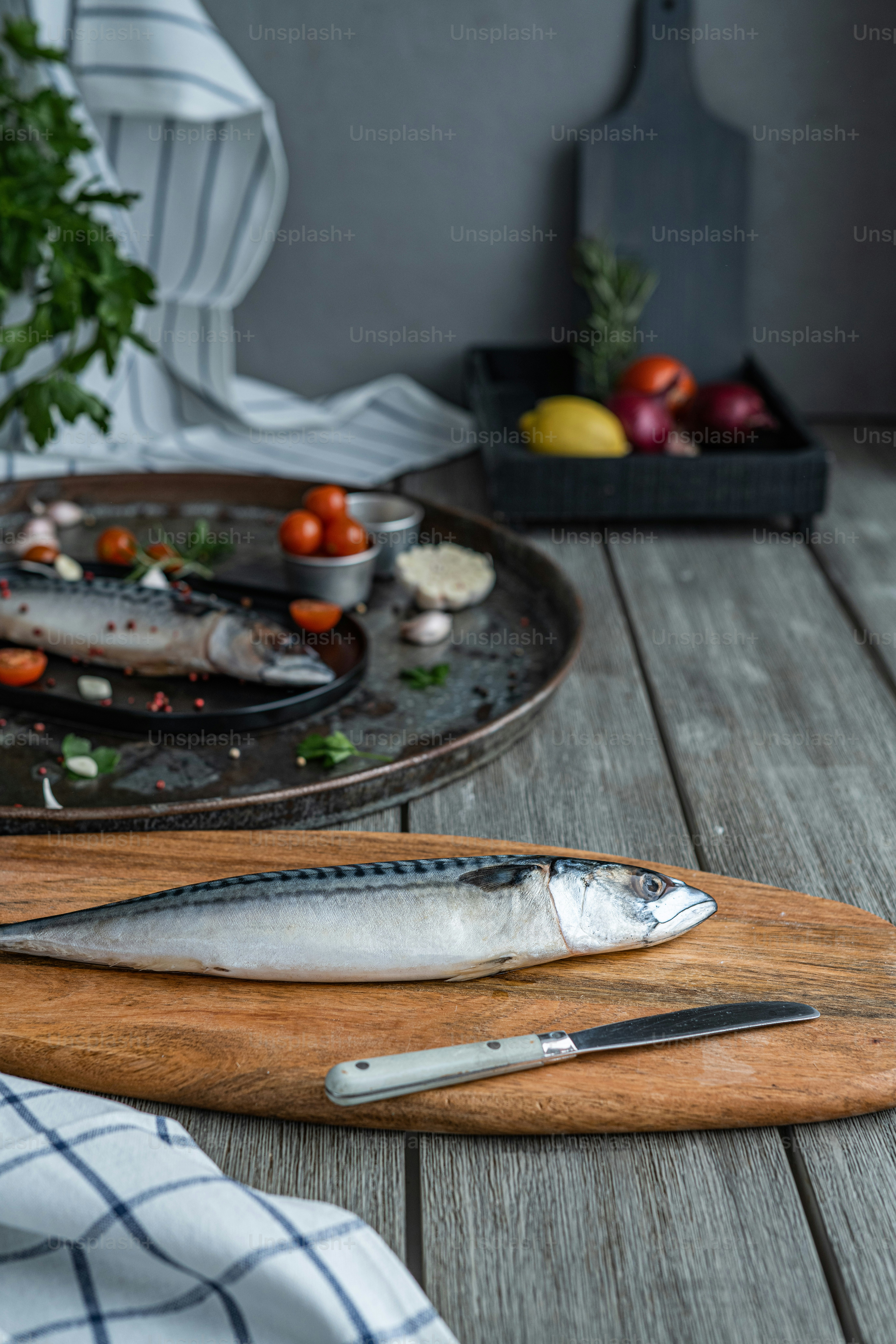 Ein Fisch sitzt auf einem Schneidebrett neben einem Messer