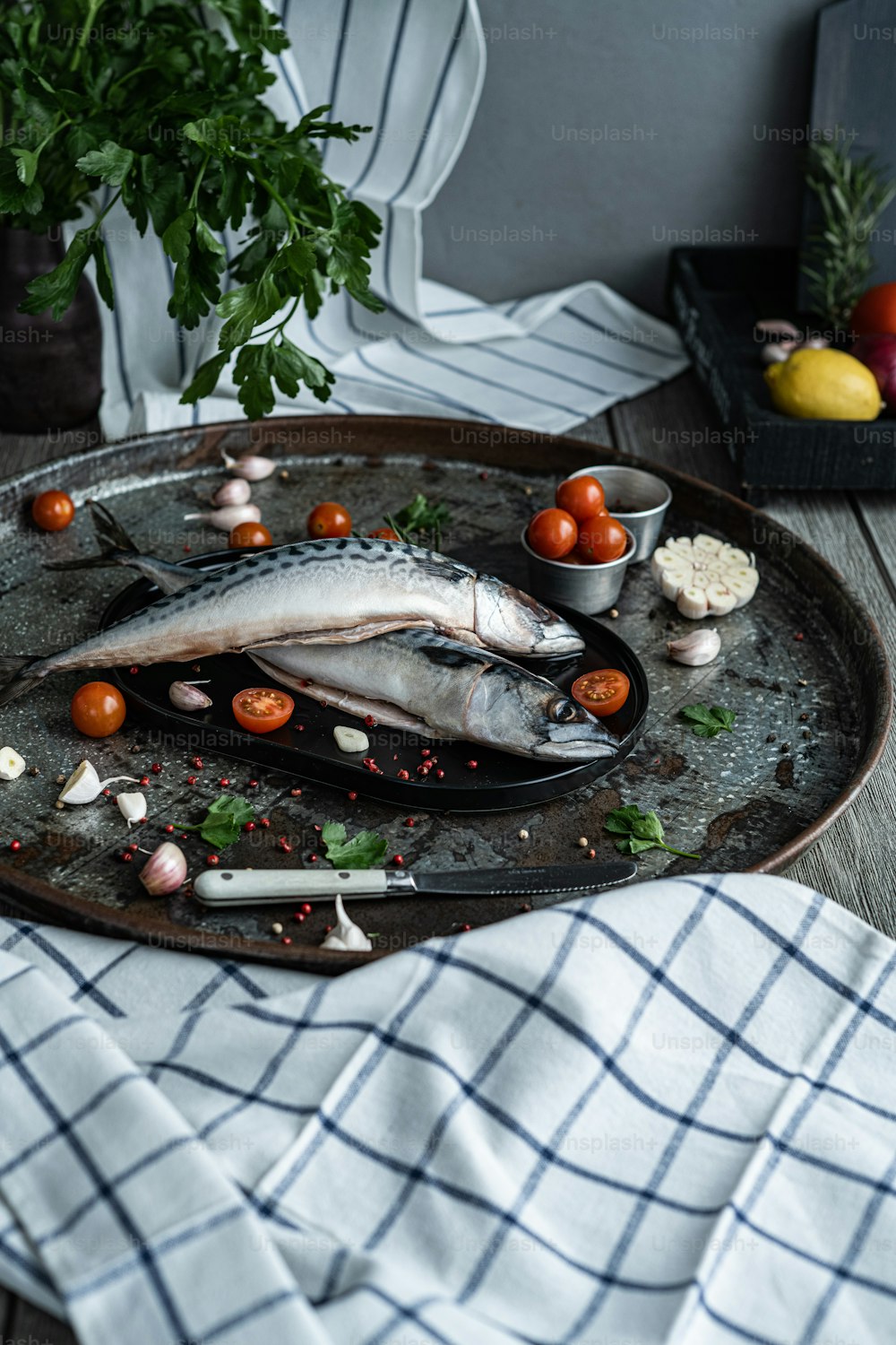 Ein Fisch ist auf einem Teller mit Tomaten und Knoblauch