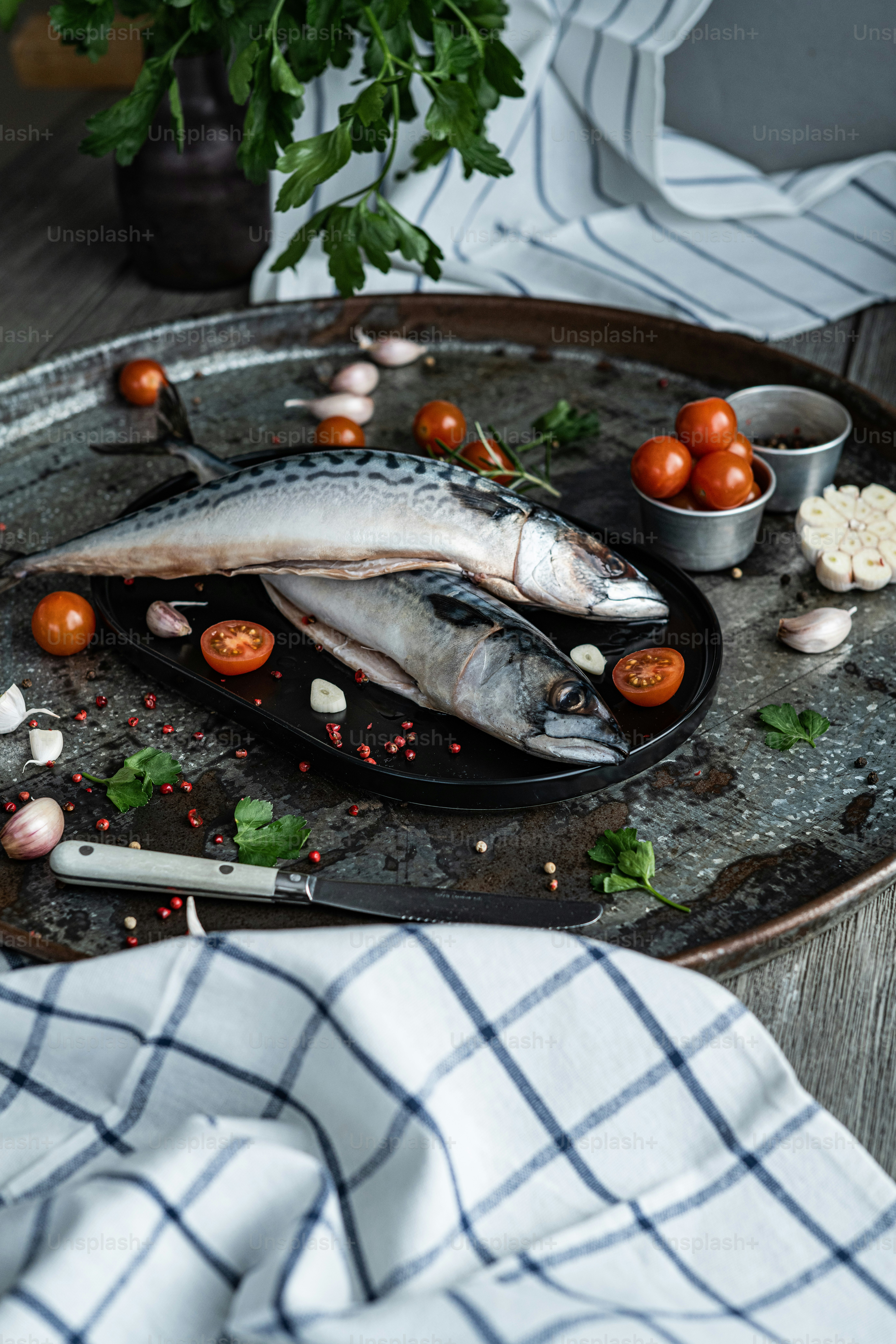 ein Teller mit etwas Fisch und Tomaten darauf