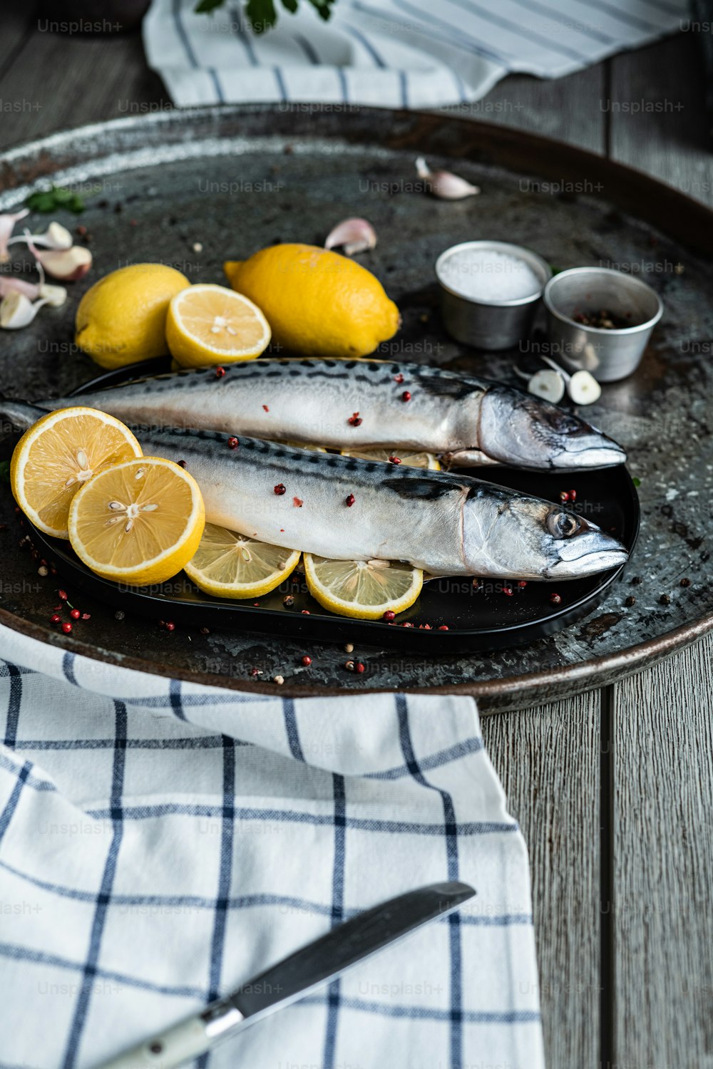 Un plato de pescado y limones sobre una mesa