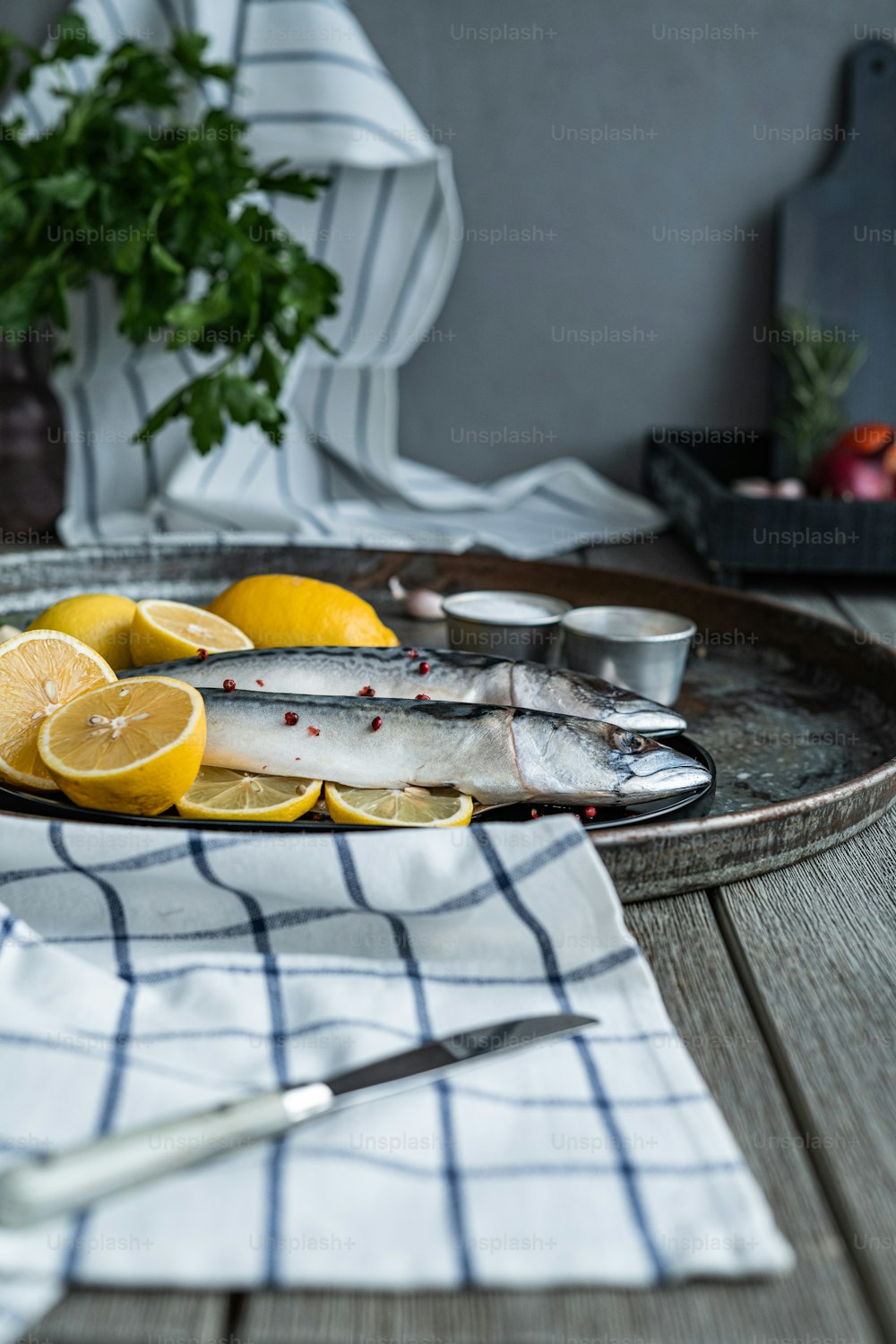 Ein Teller mit Fisch und Zitronen auf einem Tisch