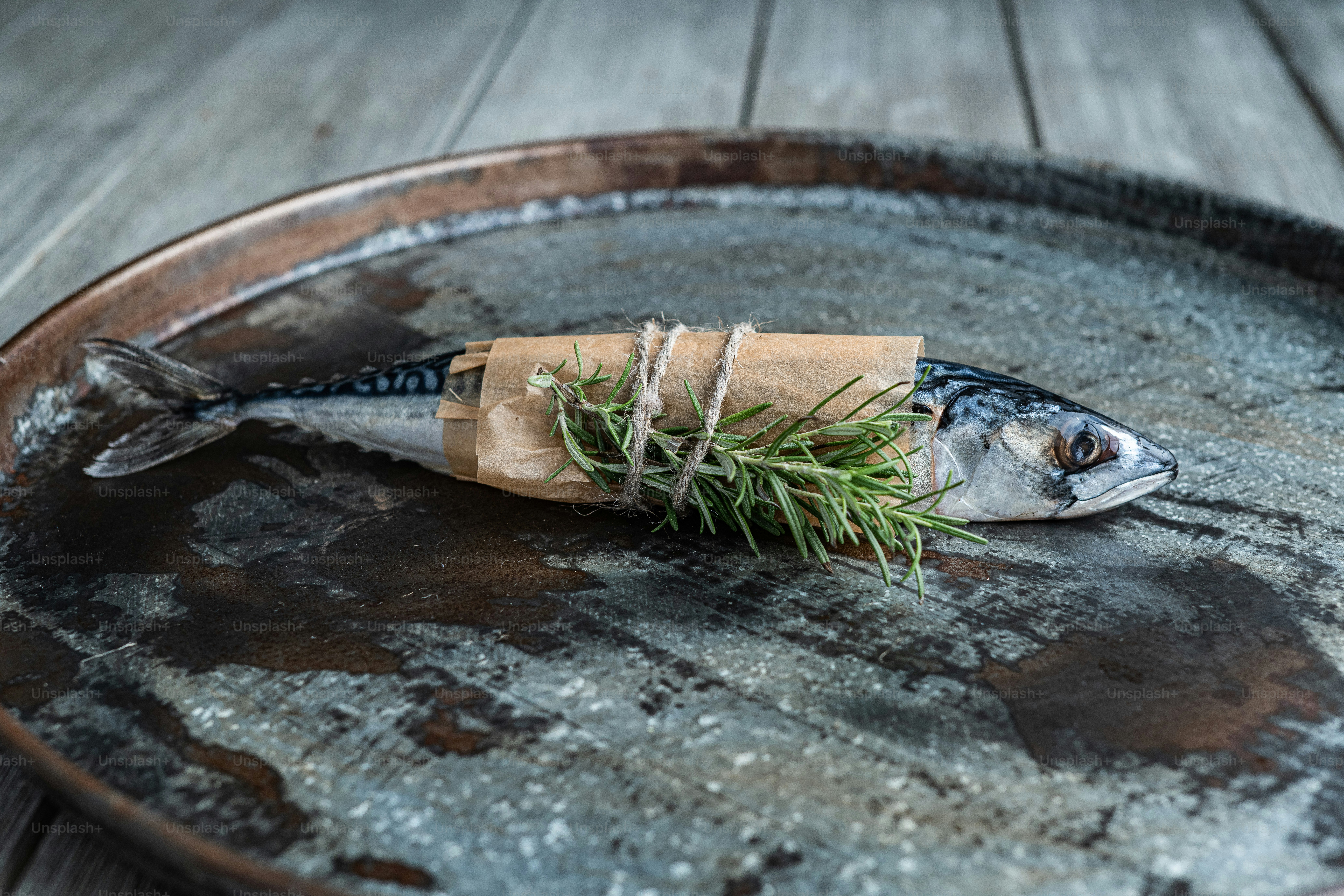 A fish wrapped in brown paper sitting on top of a wooden barrel photo ...