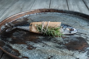 a fish wrapped in brown paper sitting on top of a wooden barrel