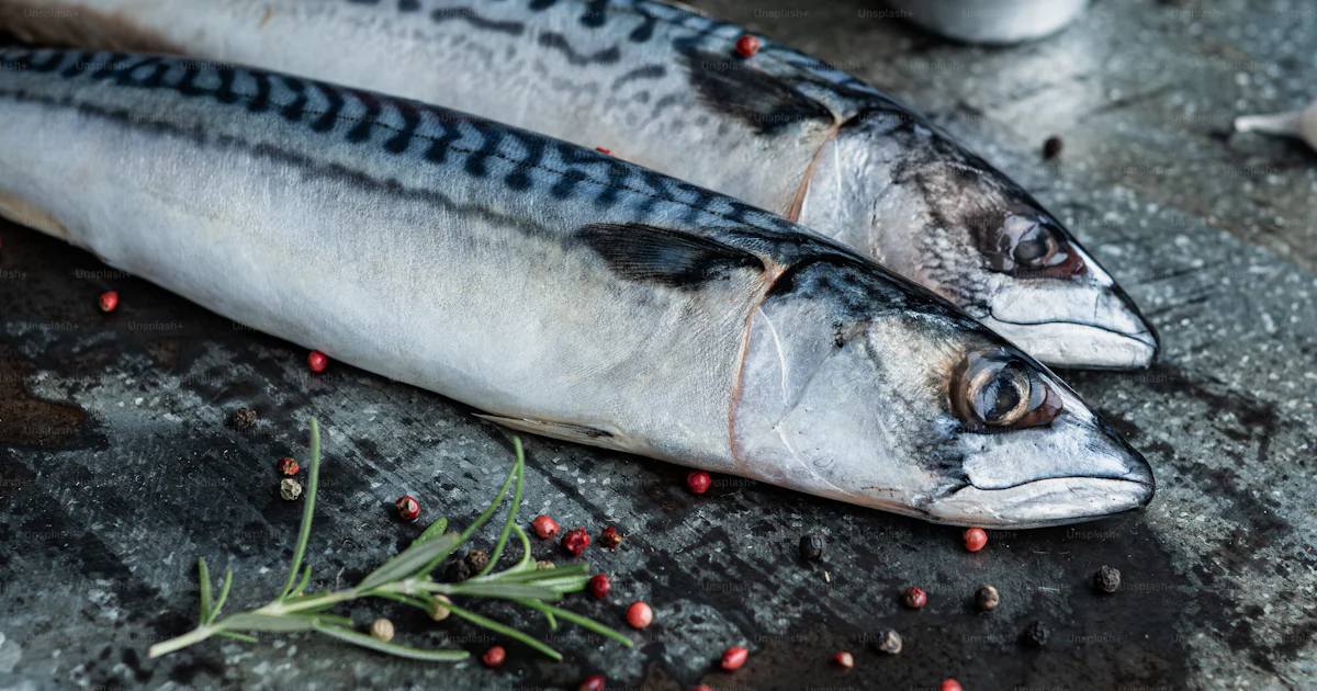A couple of fish sitting on top of a metal pan photo – Fresh fish Image ...