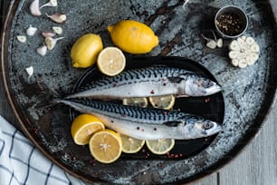 two fish on a plate with lemons and garlic