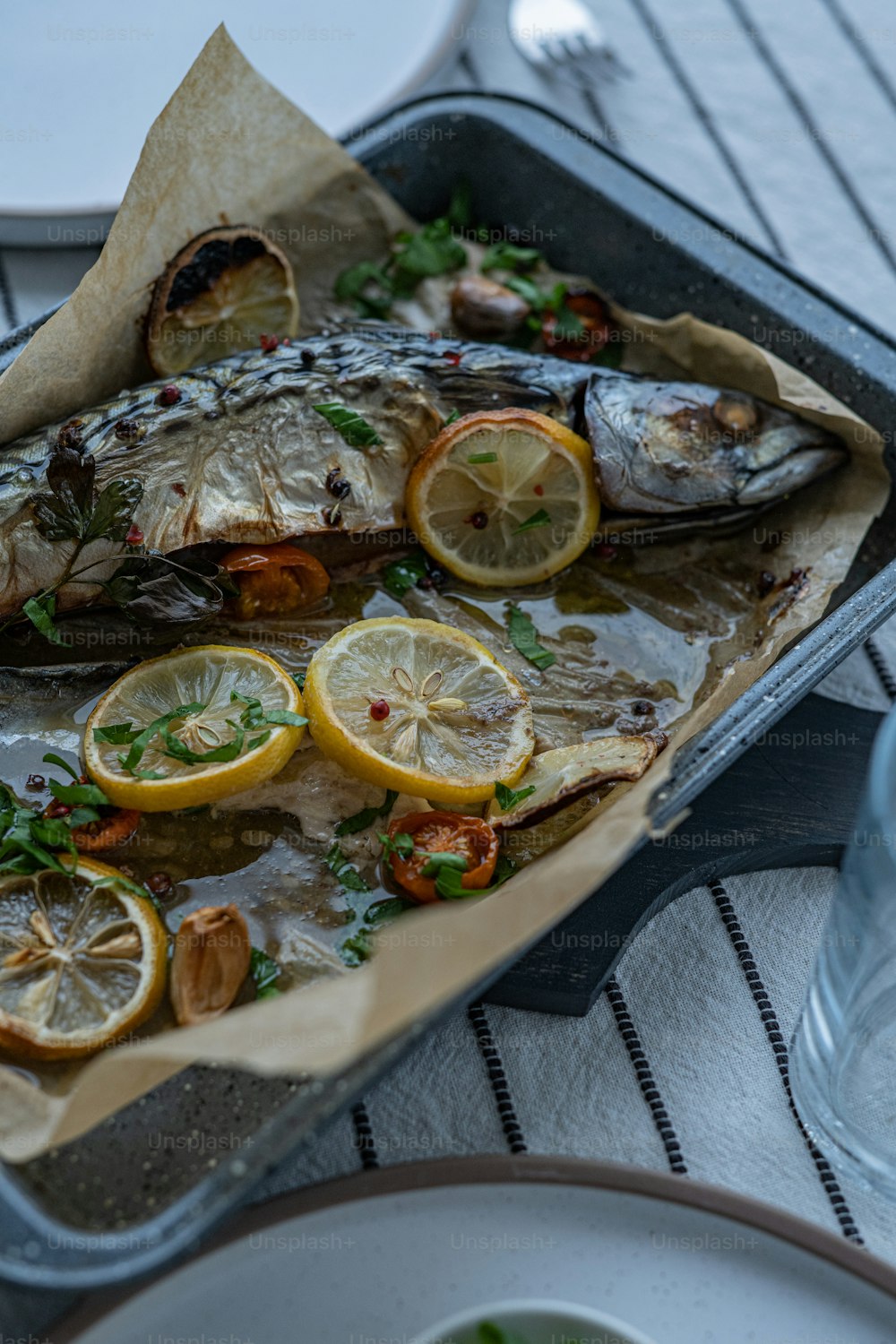 a pan filled with fish and lemon slices