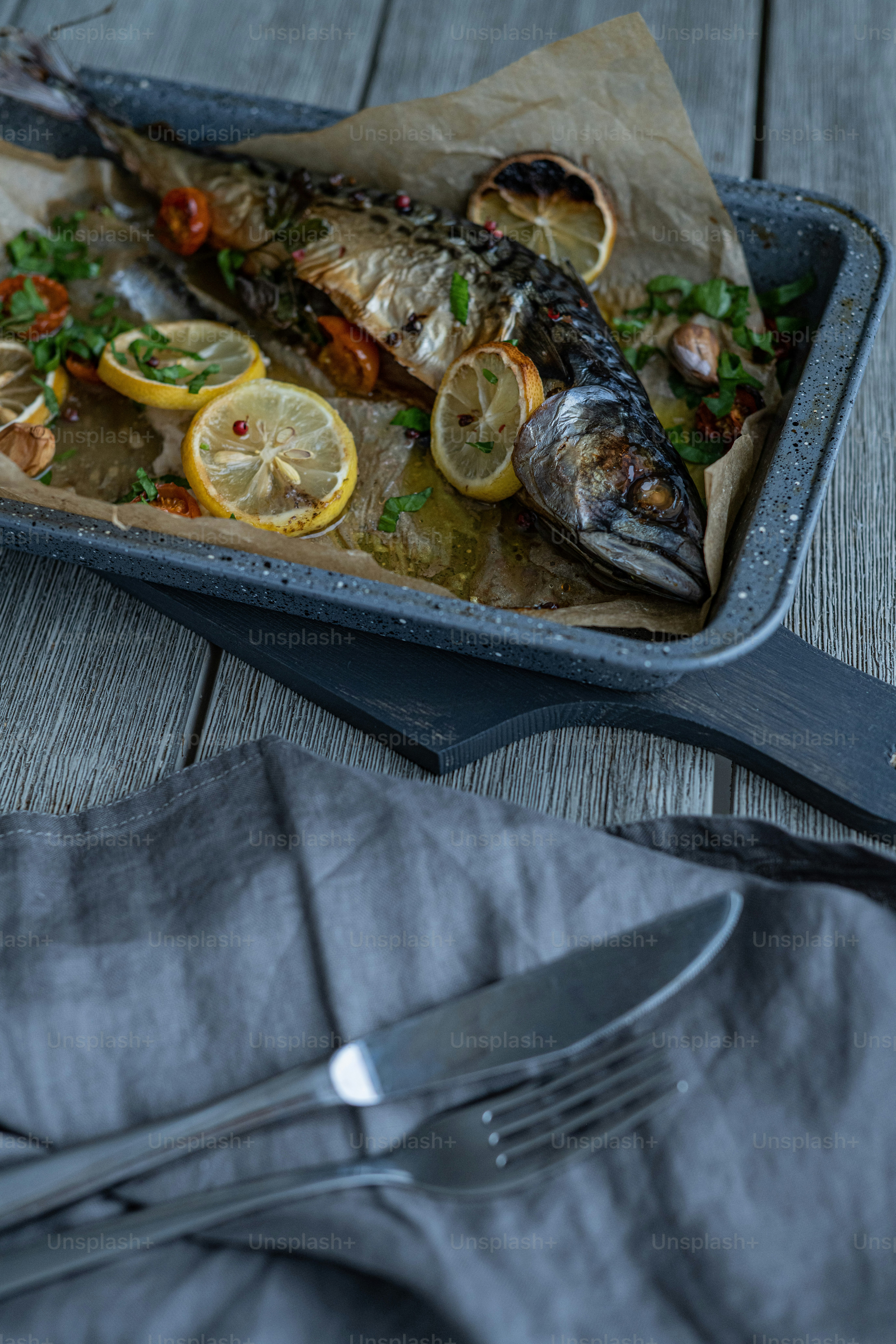 a plate of fish with lemons and parsley