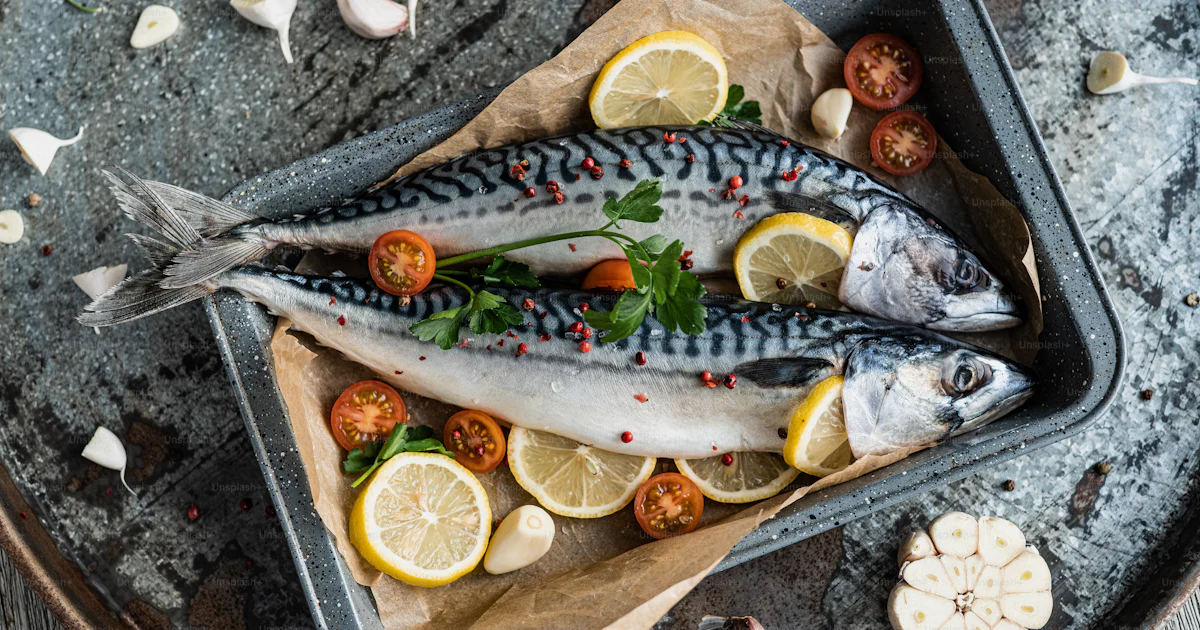 A couple of fish sitting on top of a pan photo – Fresh fish Image on ...