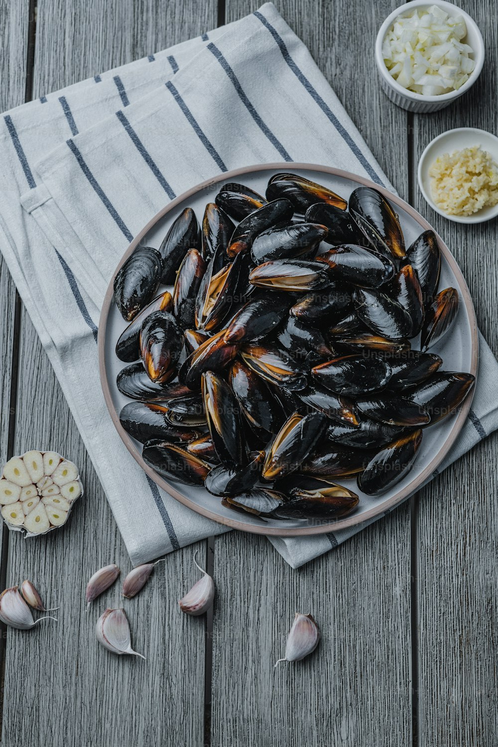 a plate full of mussels on a wooden table