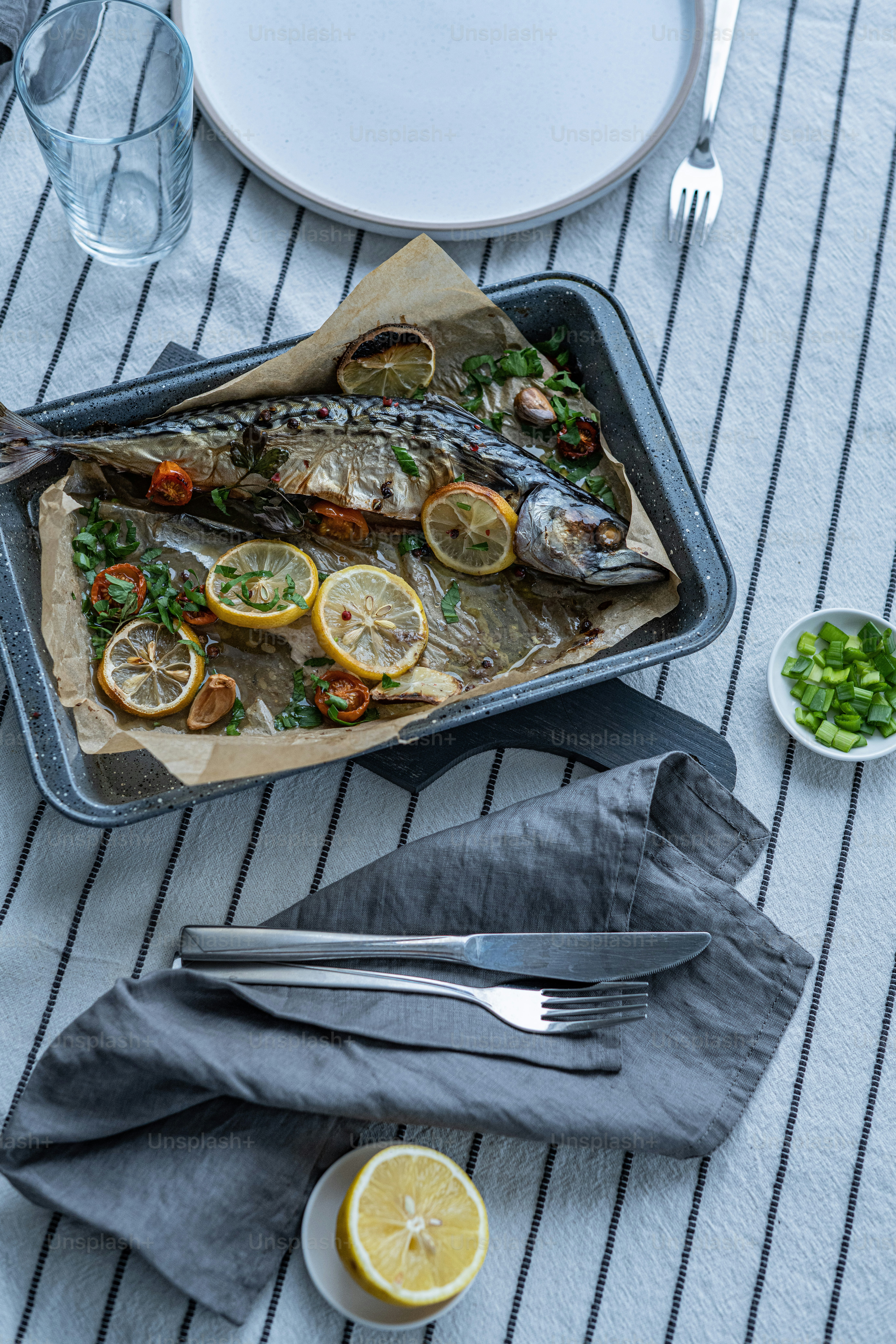 a fish is on a tray with lemons and parsley