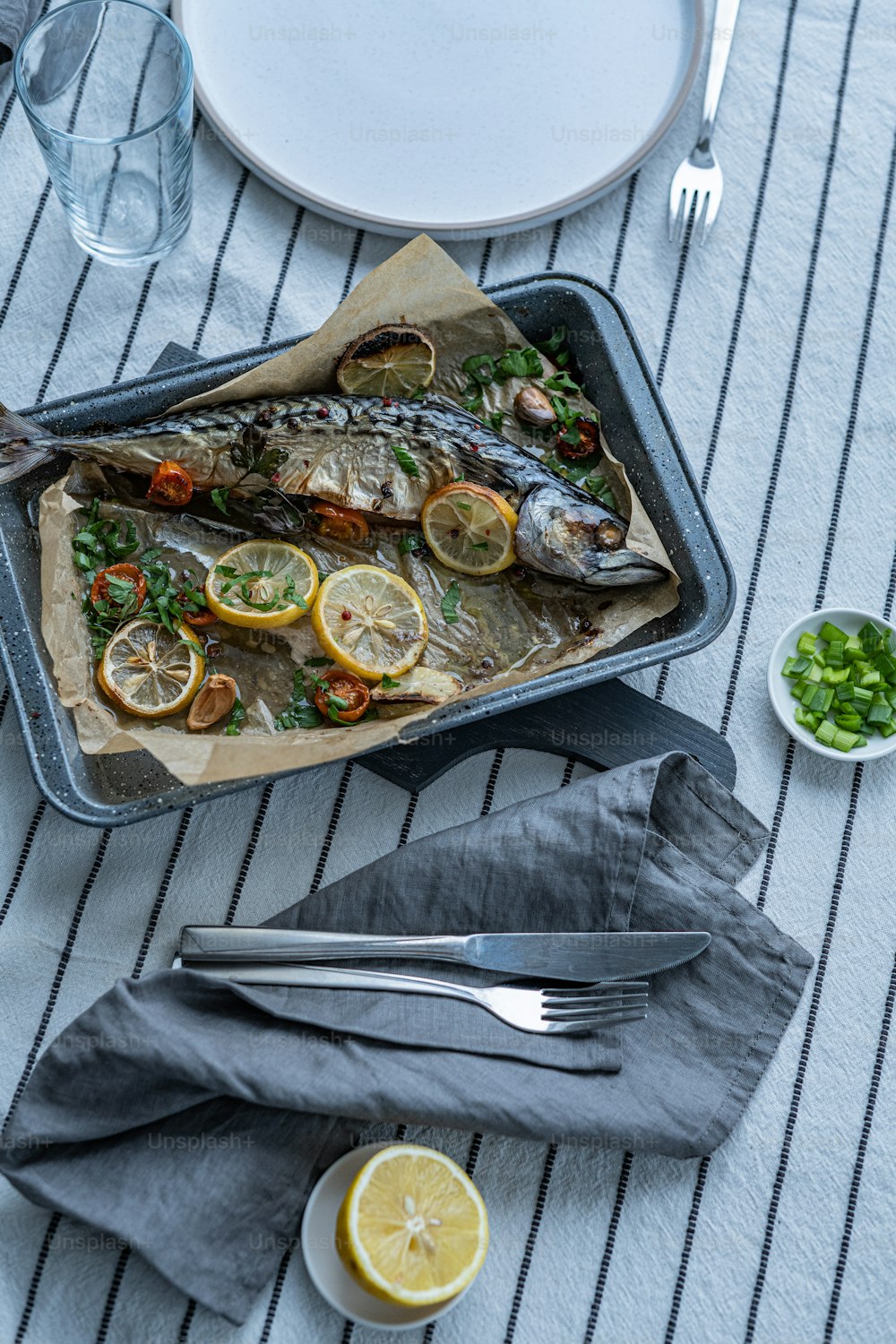 a fish is on a tray with lemons and parsley
