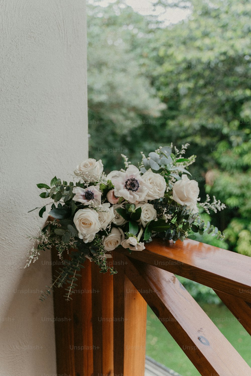 a bouquet of white flowers on a wooden railing