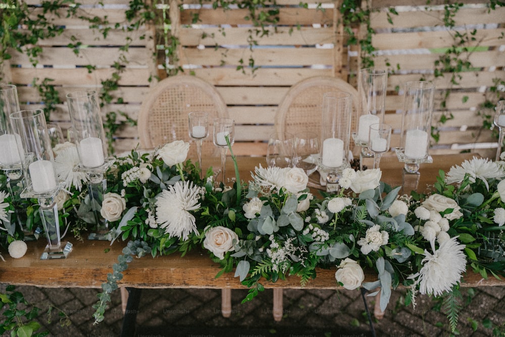 Una mesa cubierta con muchas flores blancas y vegetación