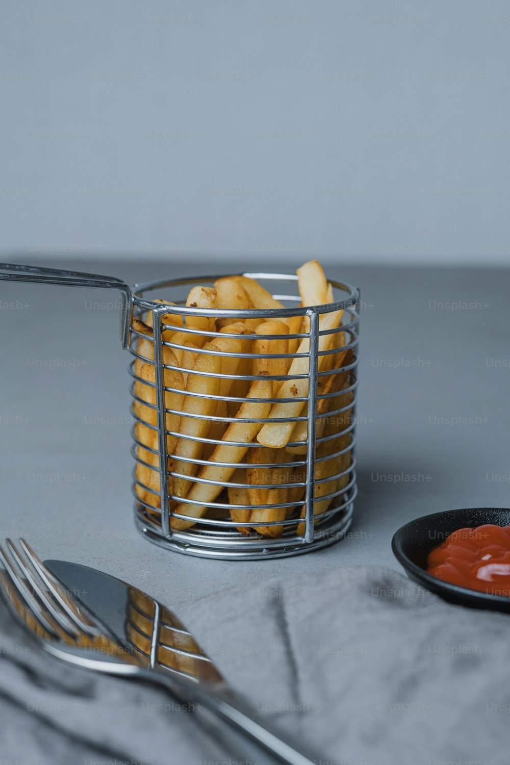 a basket of french fries with ketchup and a fork