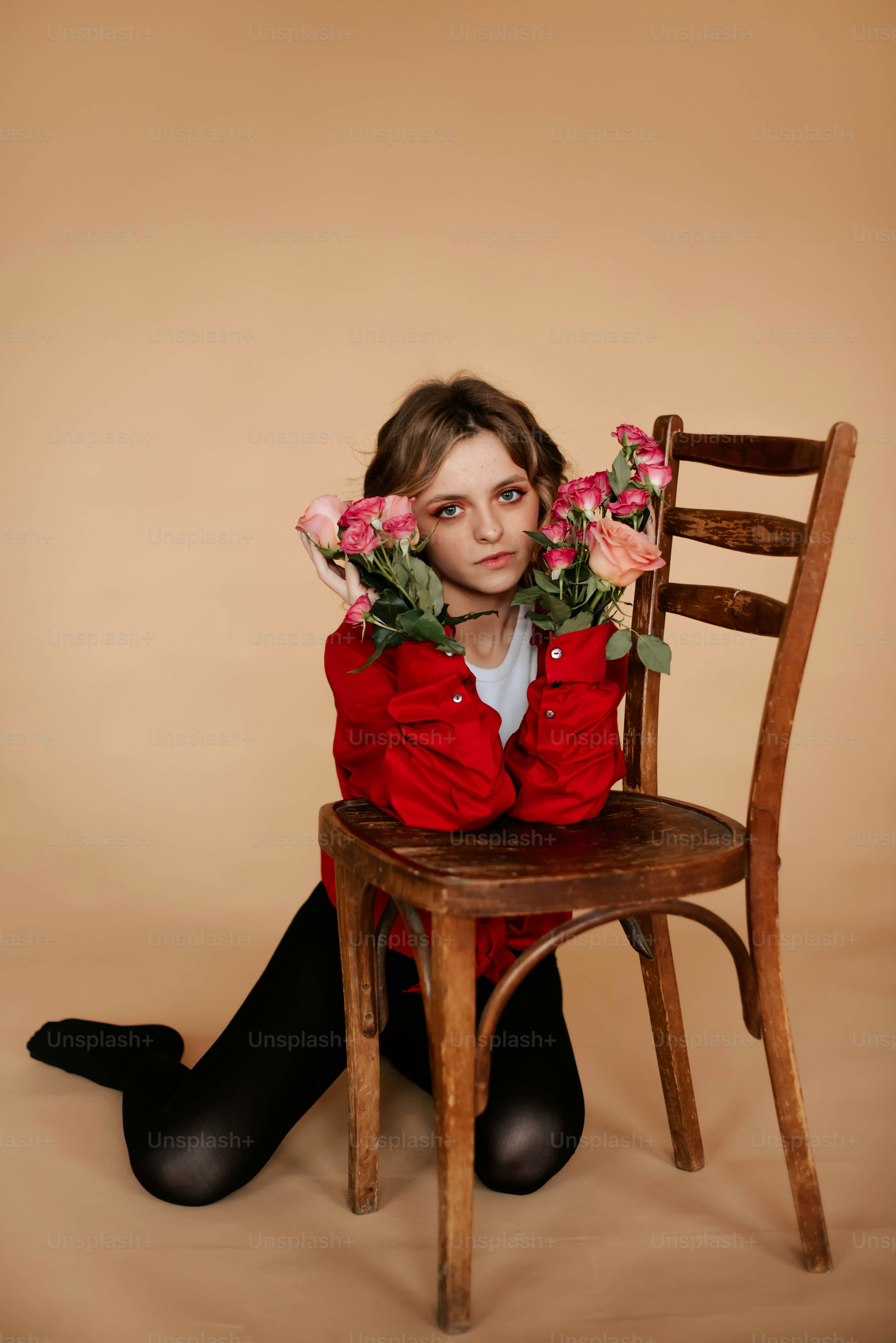 Una mujer sentada en una silla con flores en las manos