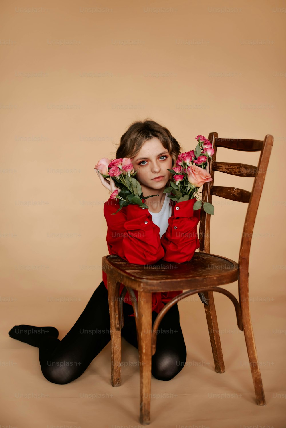 a woman sitting on a chair with flowers in her hands