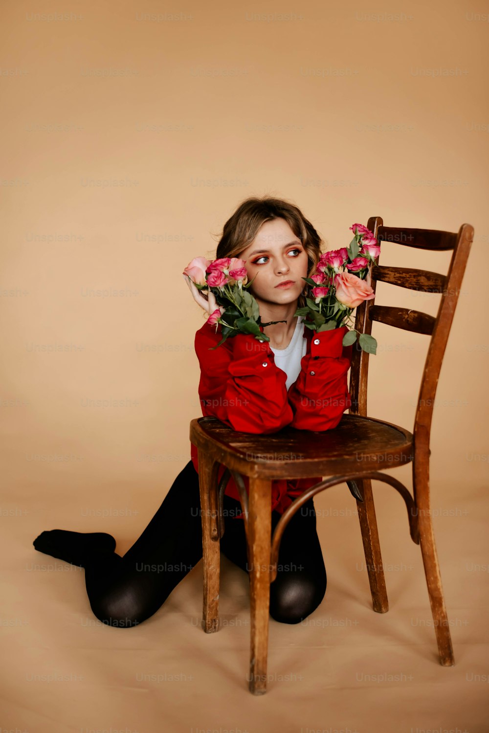 a girl sitting on a chair with flowers in her hair