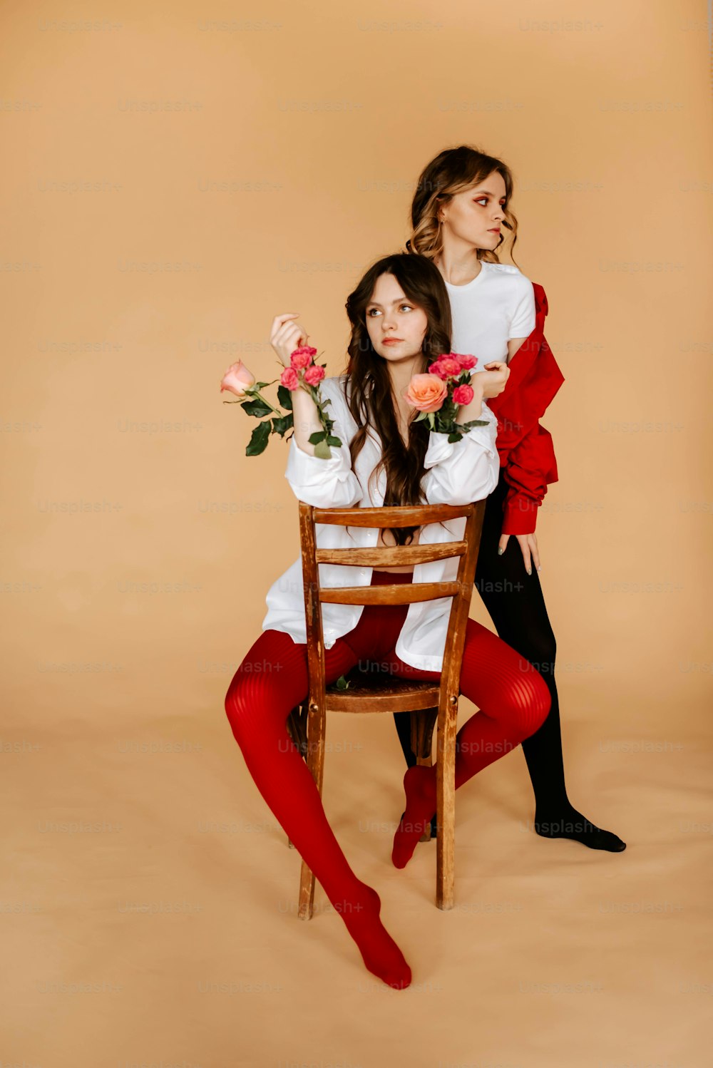 Due donne sedute su una sedia con fiori nelle loro mani