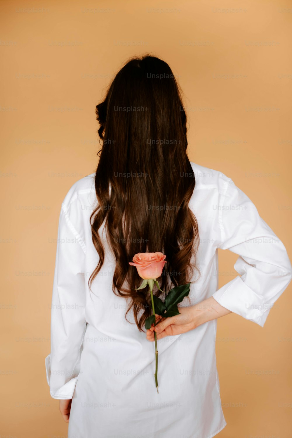 a woman with long hair holding a rose