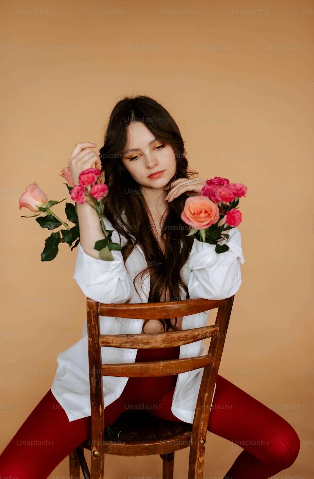 a woman sitting on a chair holding flowers