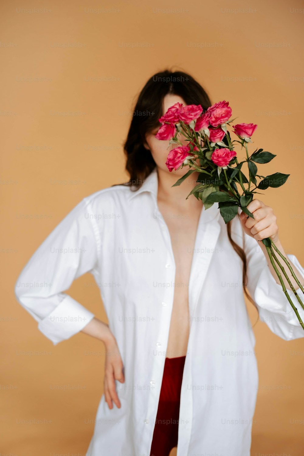 a woman in a white shirt holding a bunch of flowers