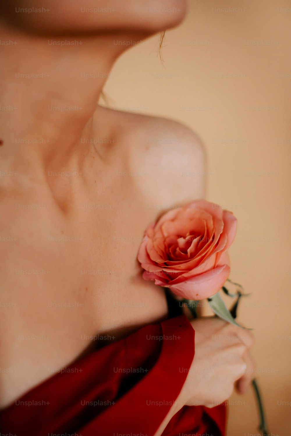 Eine Frau in einem roten Kleid hält eine Rose