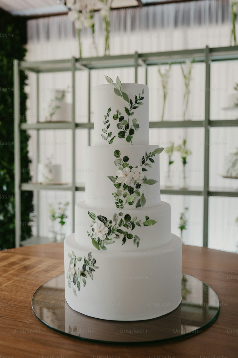 a white wedding cake with greenery on top