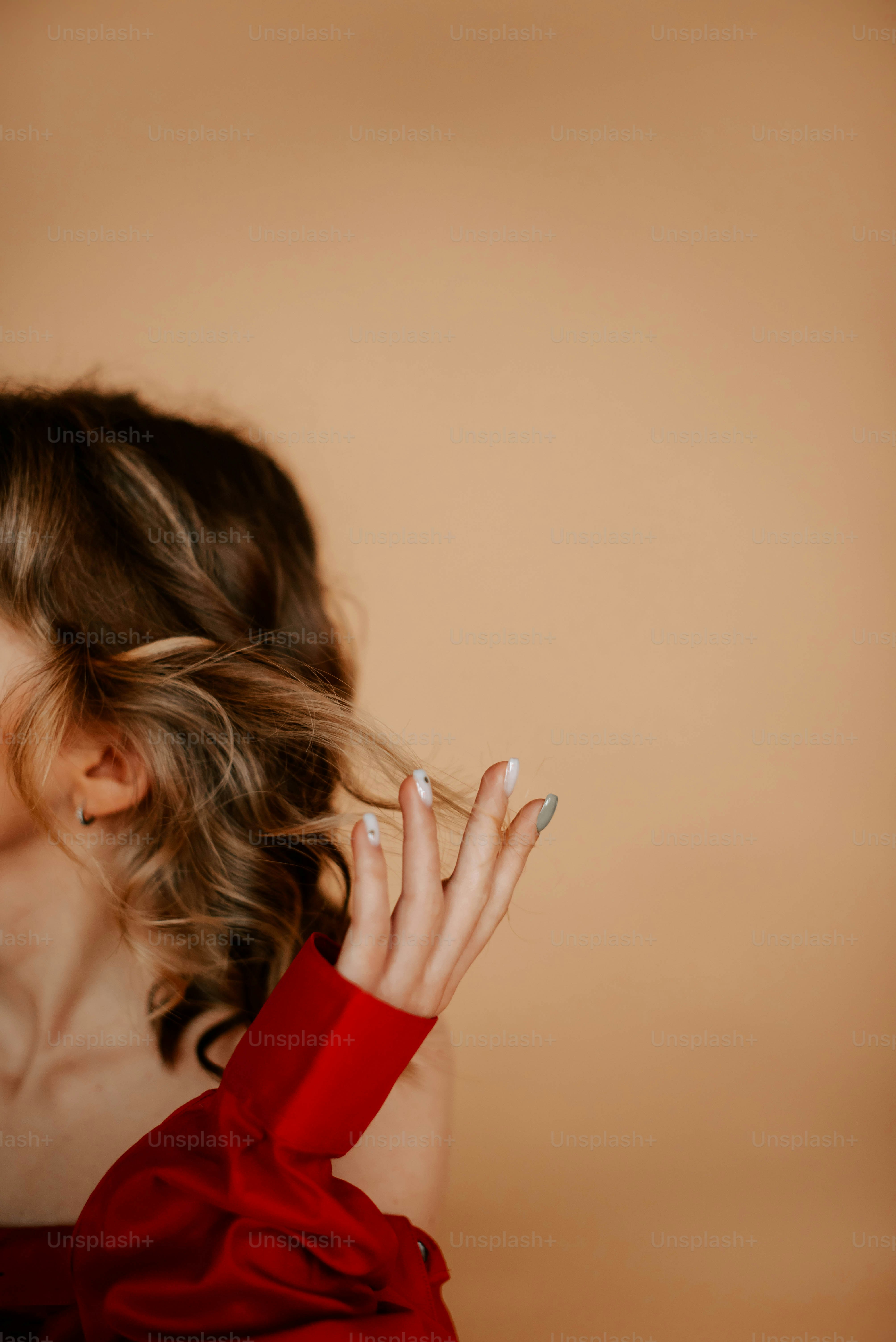 Una donna in un vestito rosso che tiene la mano fino al viso