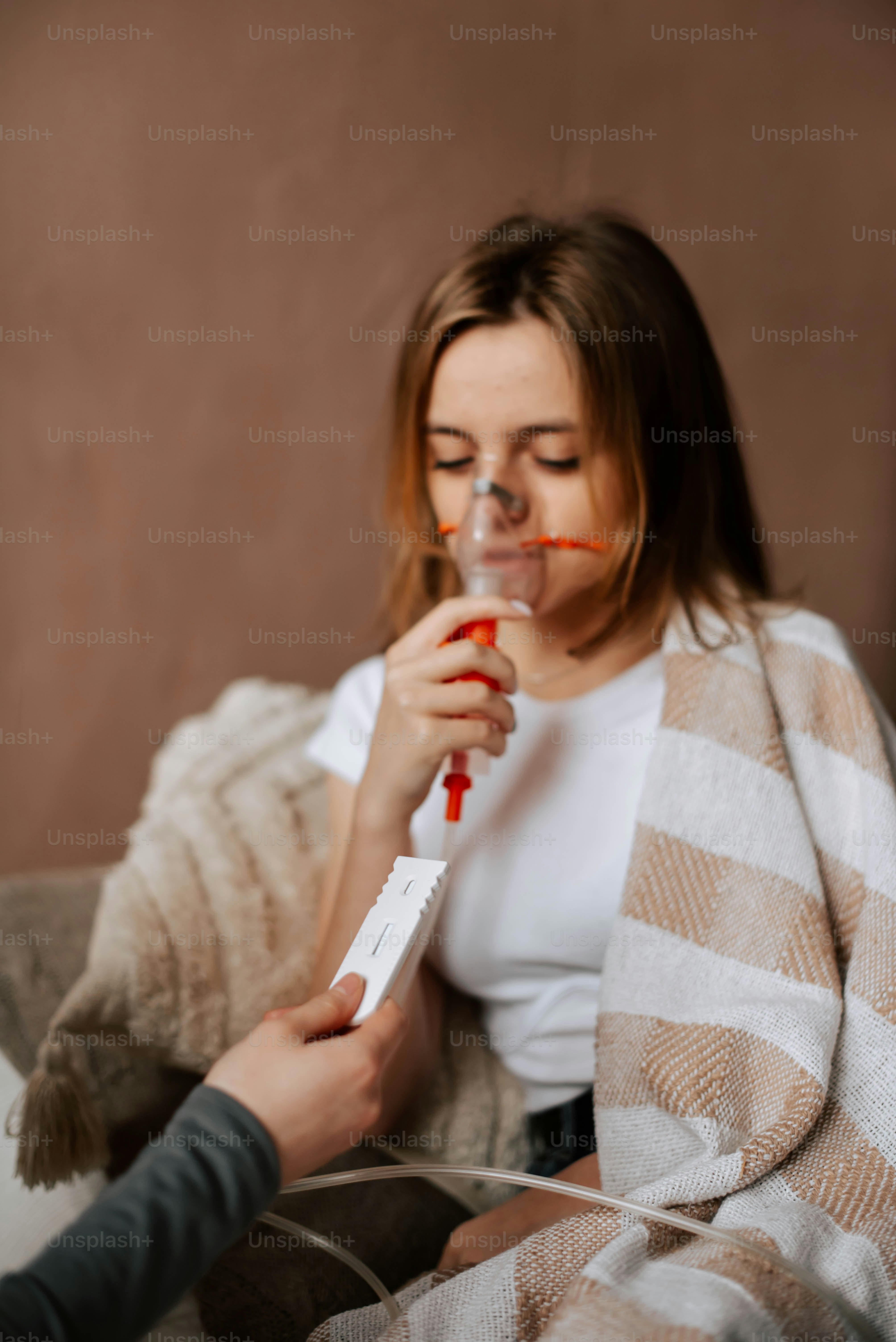 a woman sitting on a couch holding a remote control