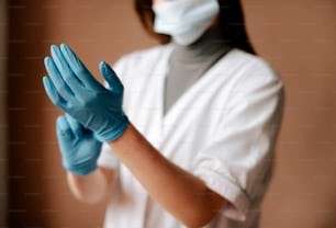 a woman wearing blue gloves and a face mask