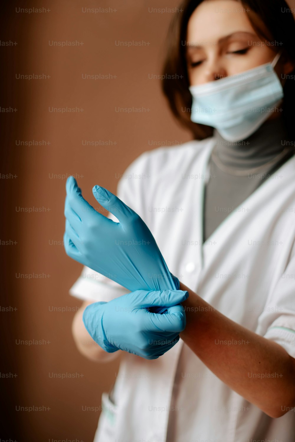 eine Frau mit blauen Handschuhen und einer Gesichtsmaske
