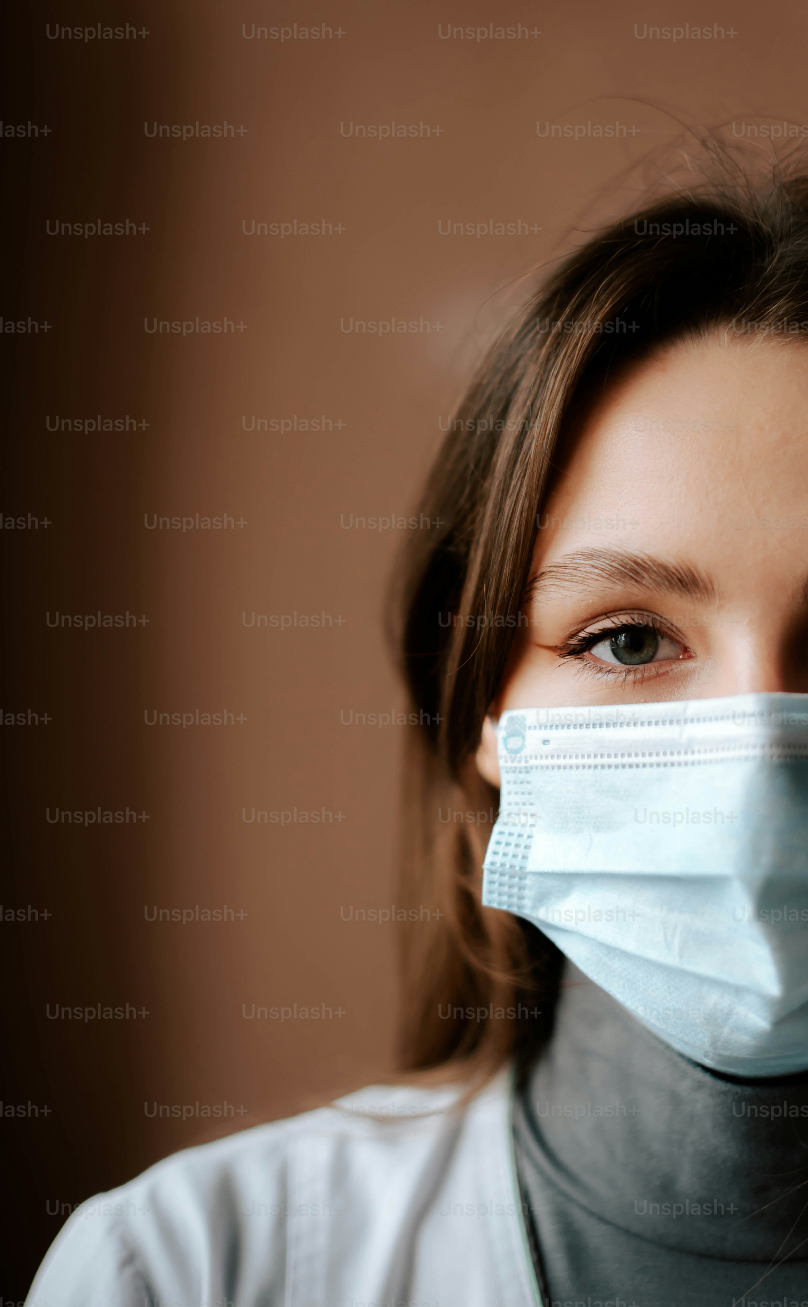 a woman wearing a face mask and looking at the camera