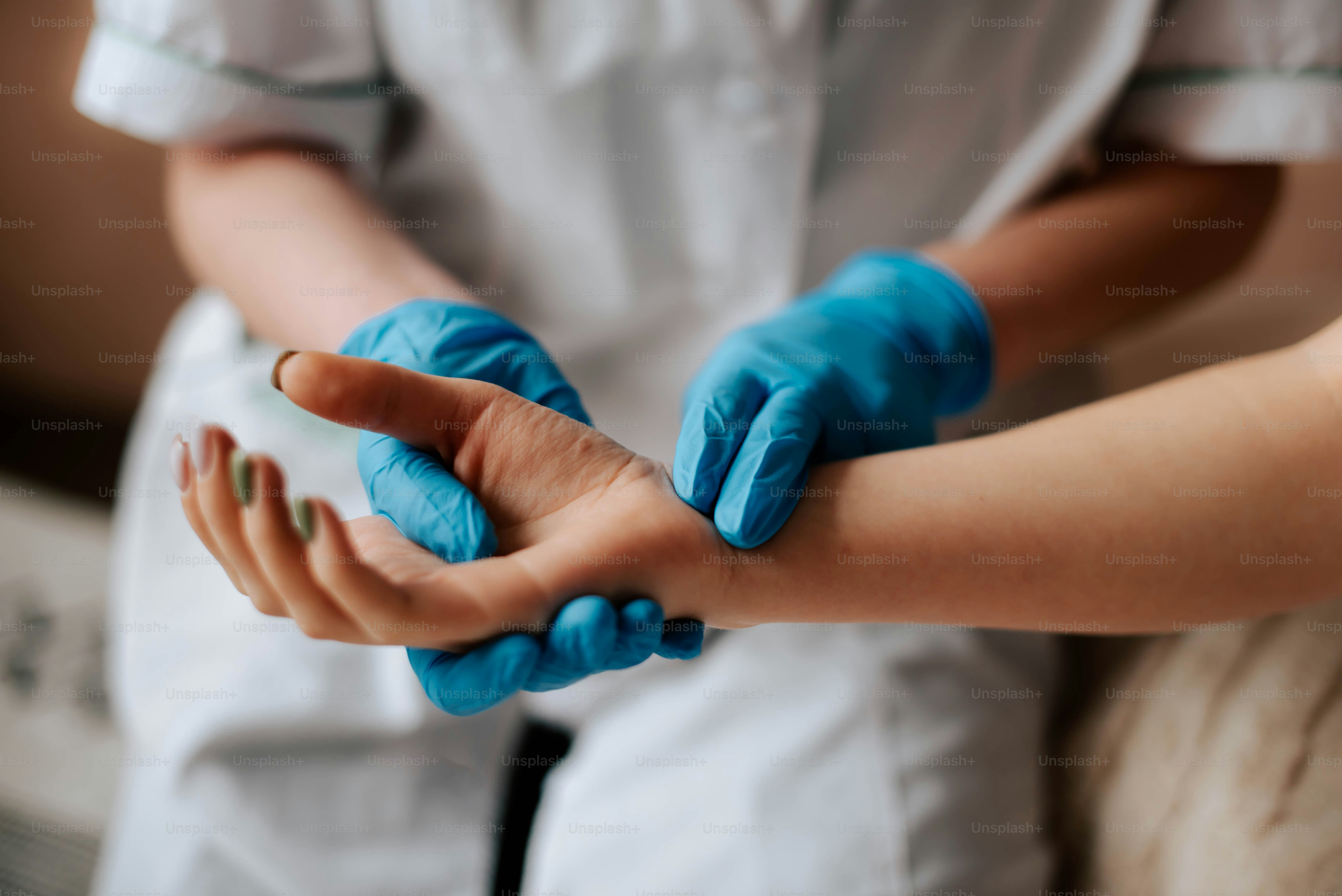 Una persona con guantes azules sosteniendo una mano pequeña