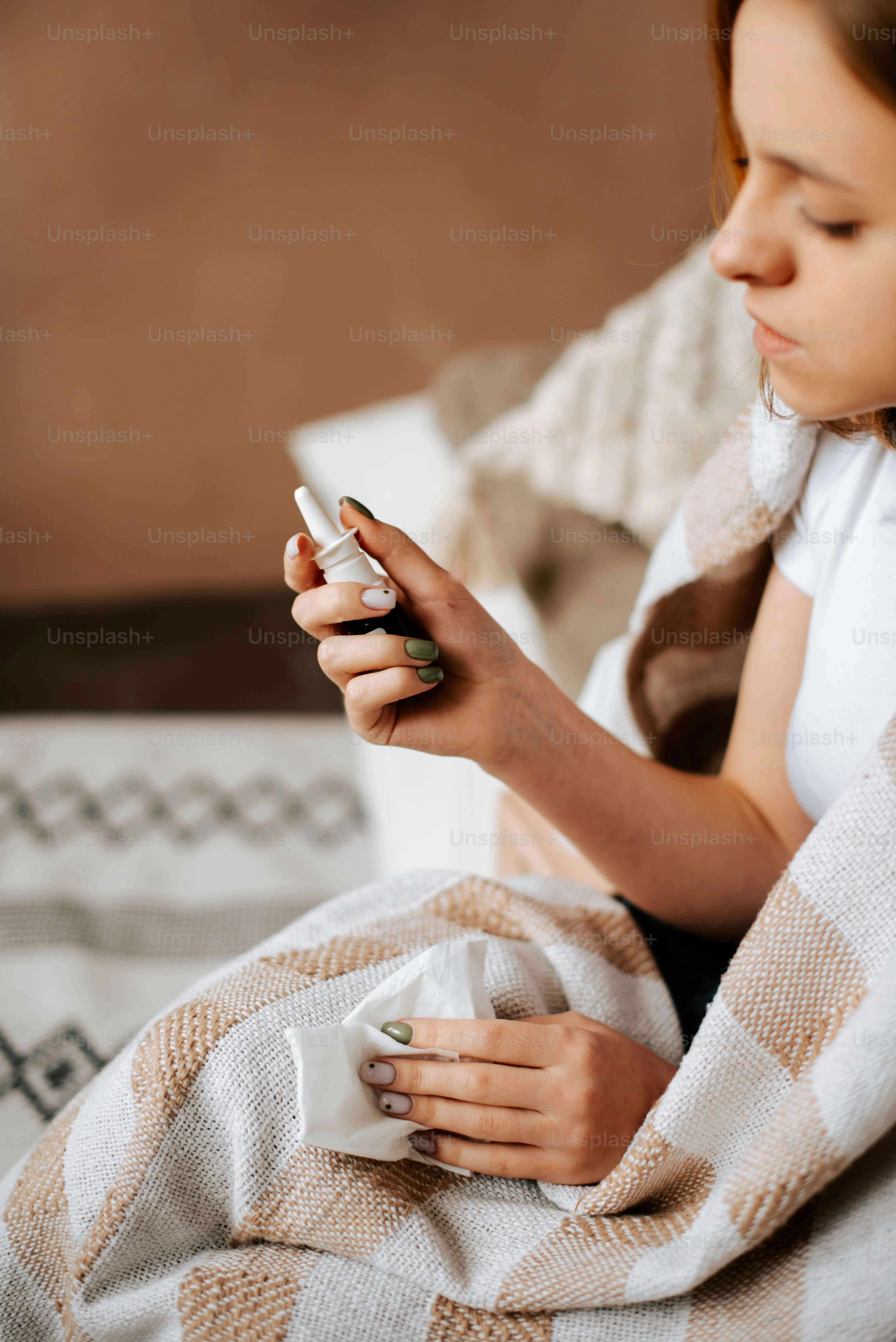 Una donna seduta su un letto che guarda il suo cellulare