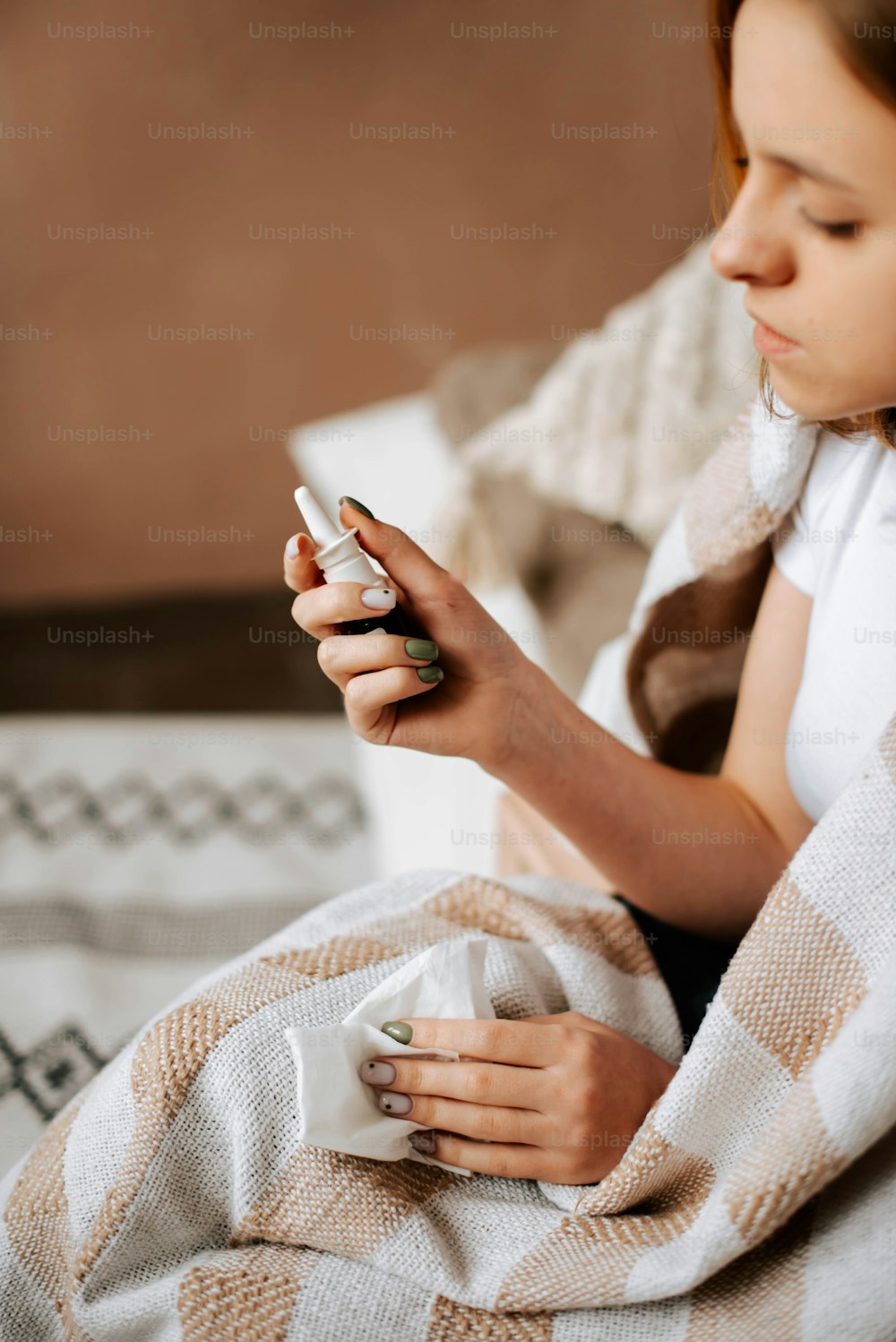 Eine Frau, die auf einem Bett sitzt und auf ihr Handy schaut