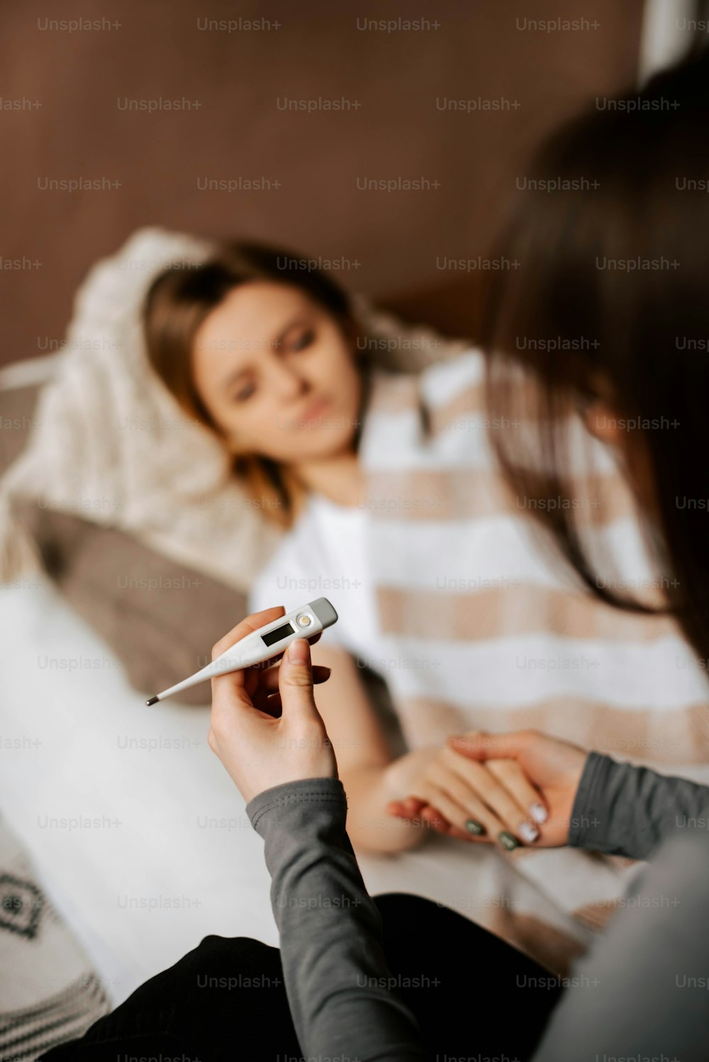 una donna seduta su un letto che tiene un telecomando