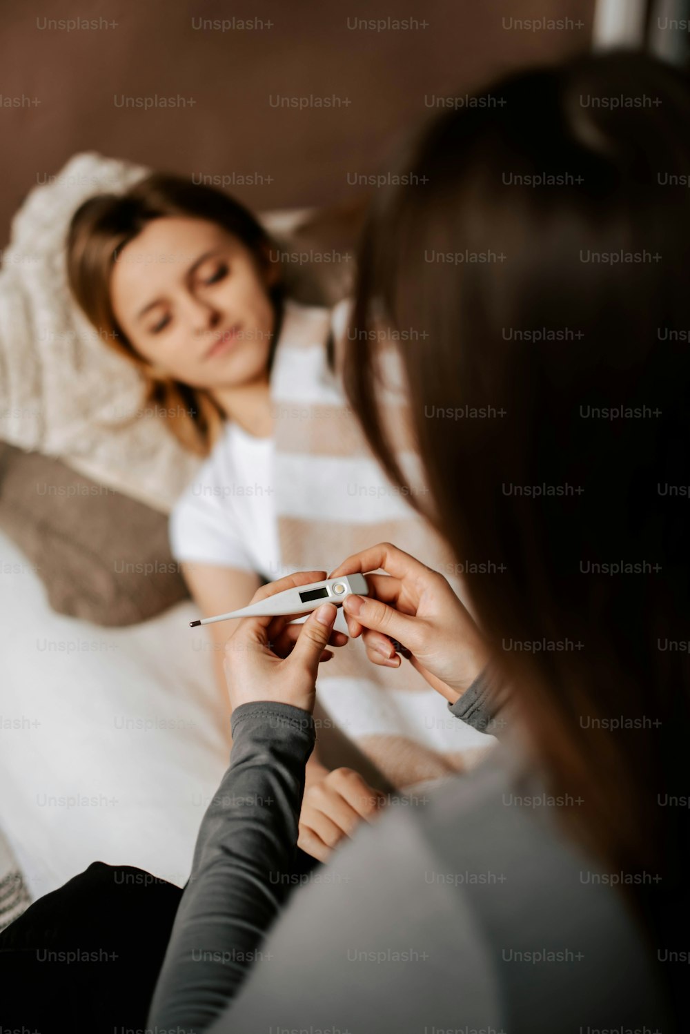 a woman sitting on a bed holding a pen