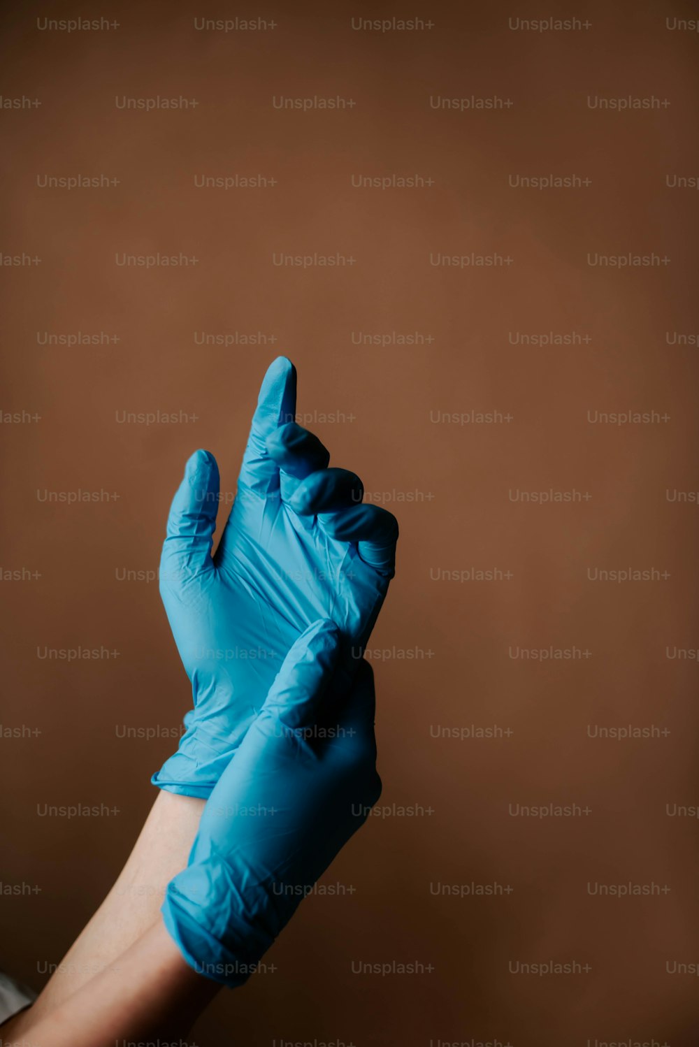una persona in guanti blu che alza la mano