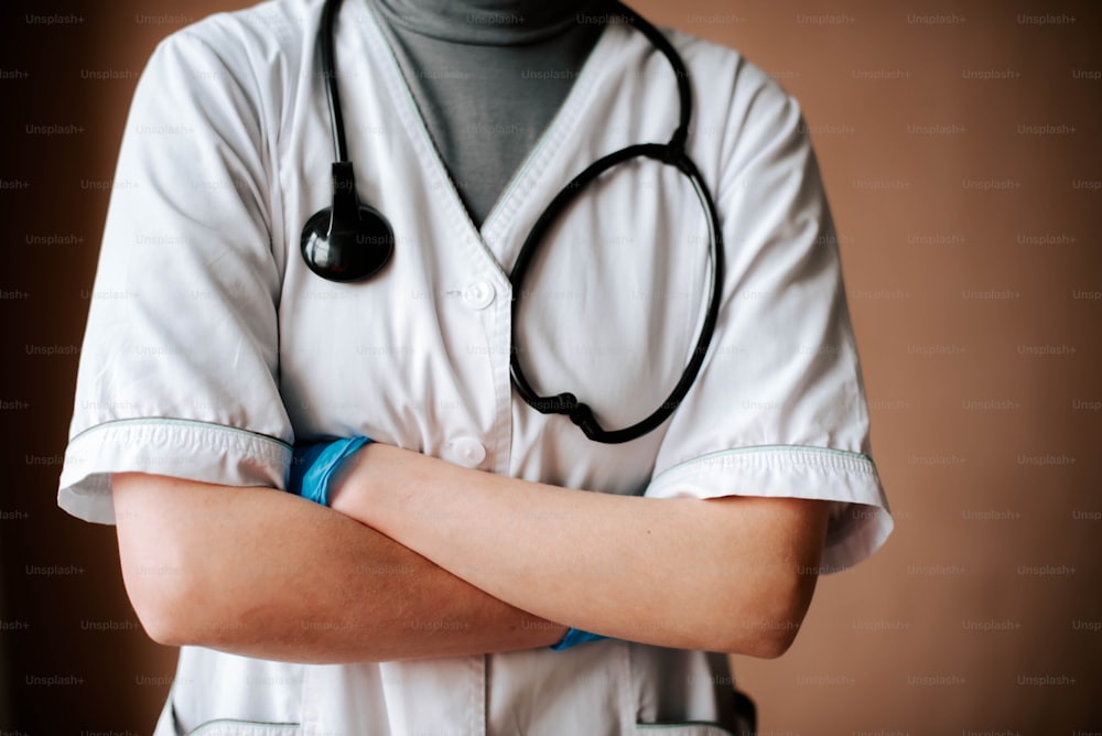 Un medico in uniforme bianca con uno stetoscopio sul braccio
