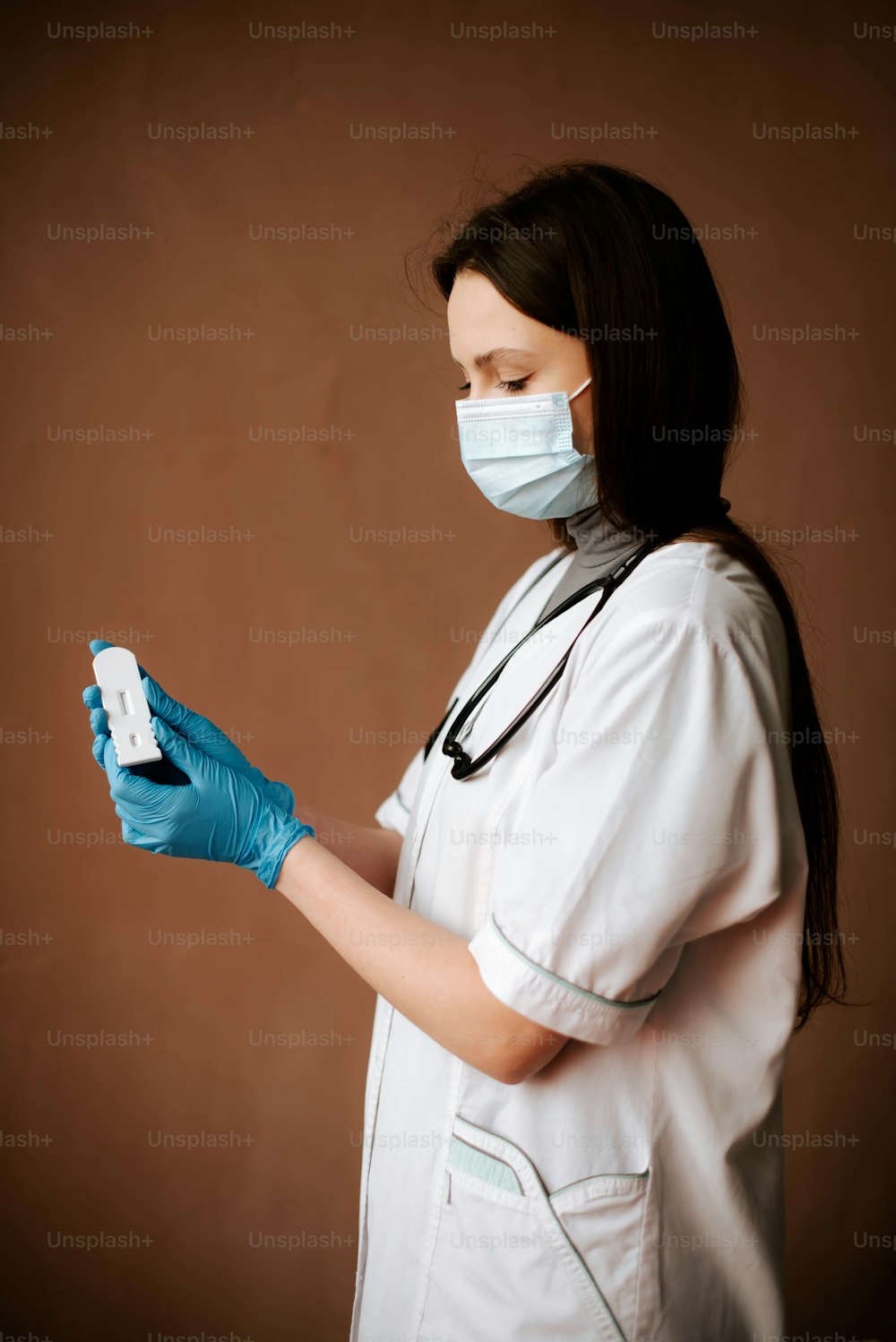Una mujer con una máscara y guantes sosteniendo un control remoto
