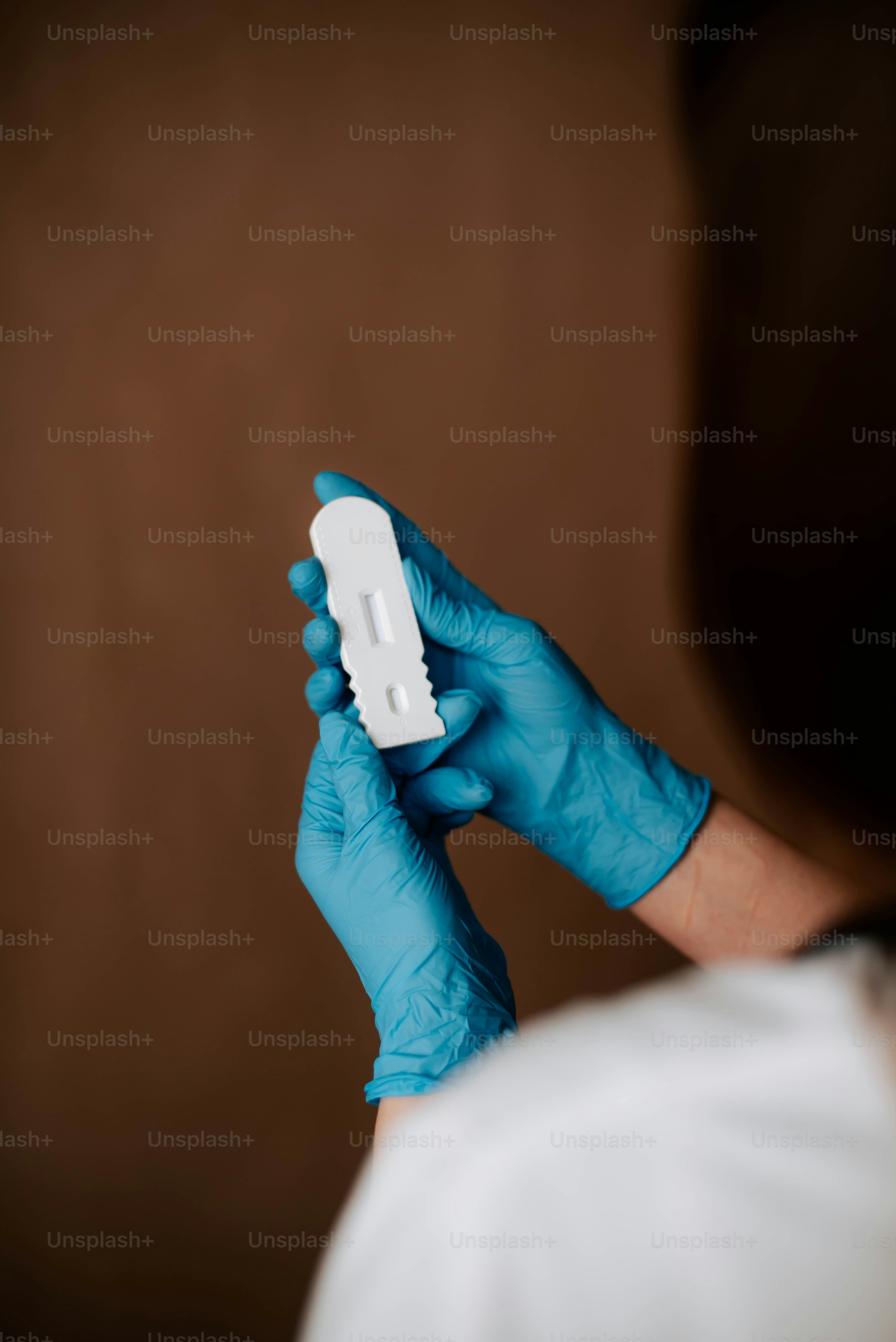 a person in blue gloves holding a white object